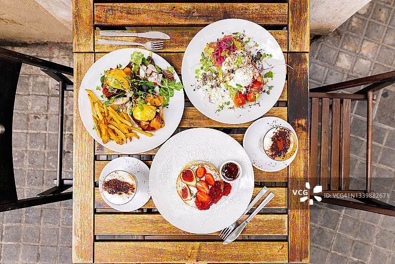 餐厅里的班尼迪克蛋、牛油果吐司和煎饼早午餐（高角度）图片素材