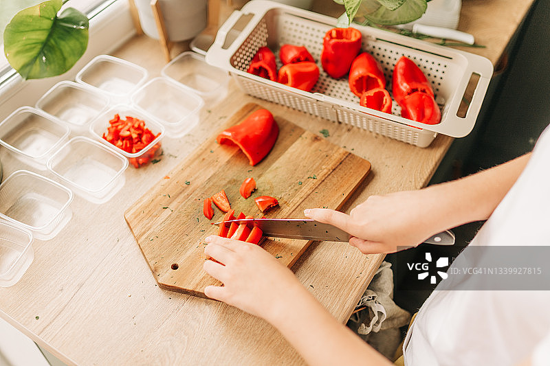 冬季食物储备：厨师将甜椒放入塑料容器冷冻图片素材