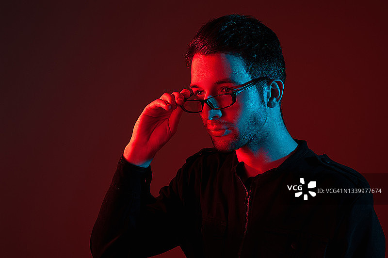 霓虹灯光下戴眼镜的棕发男士摄影棚肖像图片素材