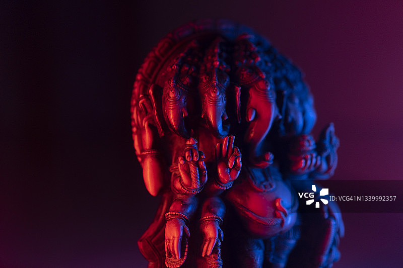 拥有多种颜色对比背景的印度教成功之神伽内什雕像的特写镜头图片素材
