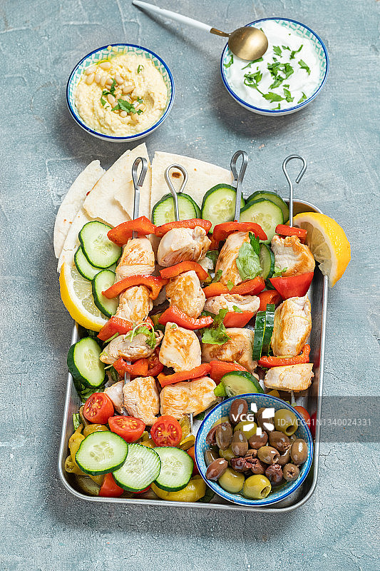 搭配酸奶鹰嘴豆泥和橄榄的鸡肉串图片素材