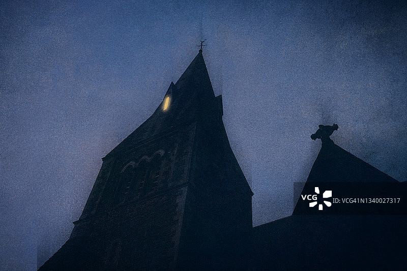 在黑暗阴郁的夜晚，古老教堂窗户中发出的神秘光芒图片素材