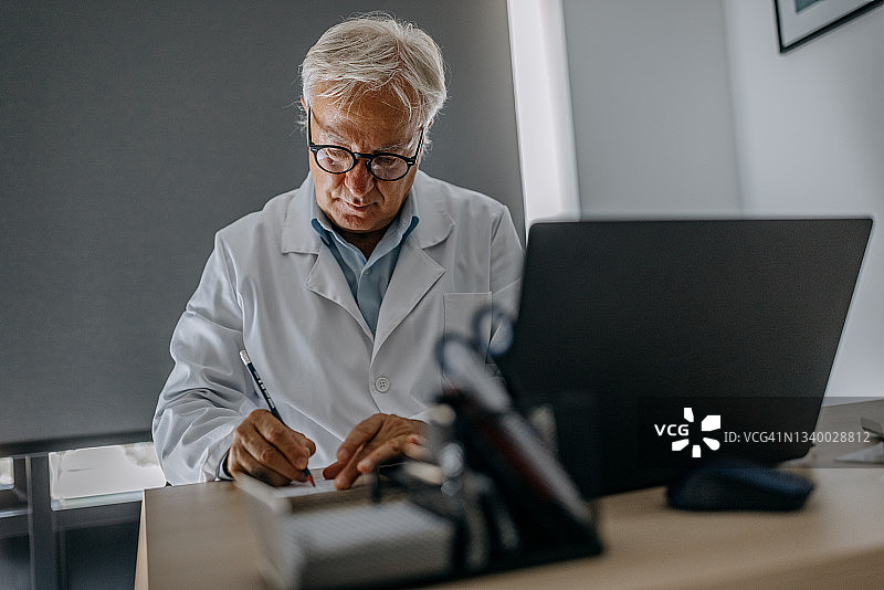 医生在工作台为病人开处方图片素材