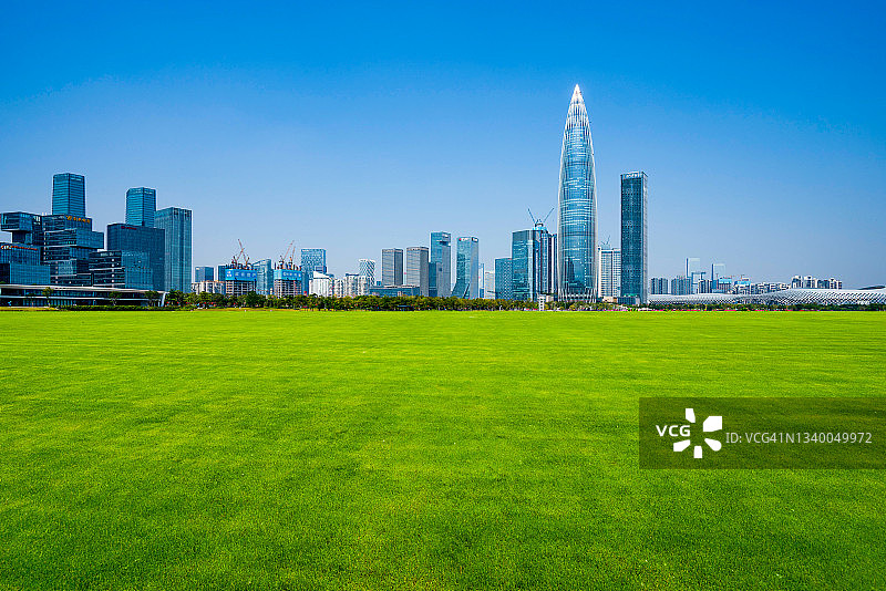 绿色草甸与现代城市天际线图片素材