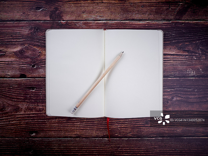 旧木桌上的空白笔记本和铅笔图片素材