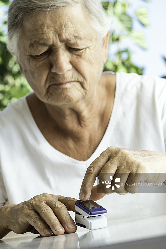 年长的女人使用血氧仪图片素材