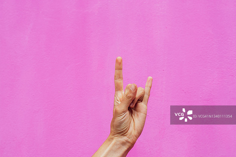 粉色背景摇滚重金属手势图片素材