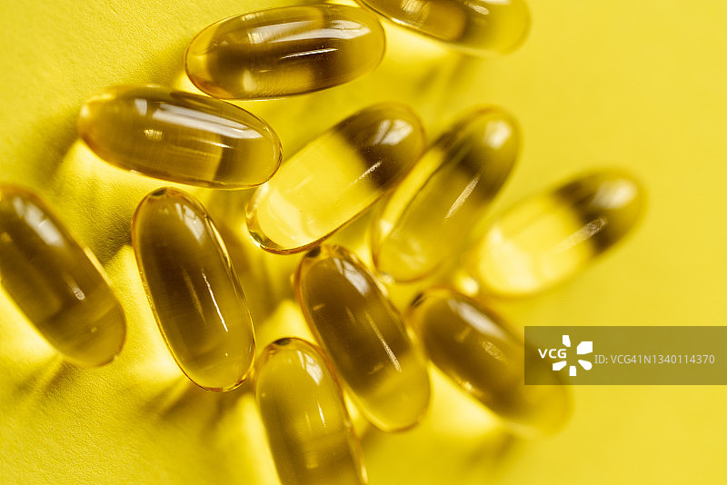 黄色背景上的Omega-3脂肪酸胶囊图片素材
