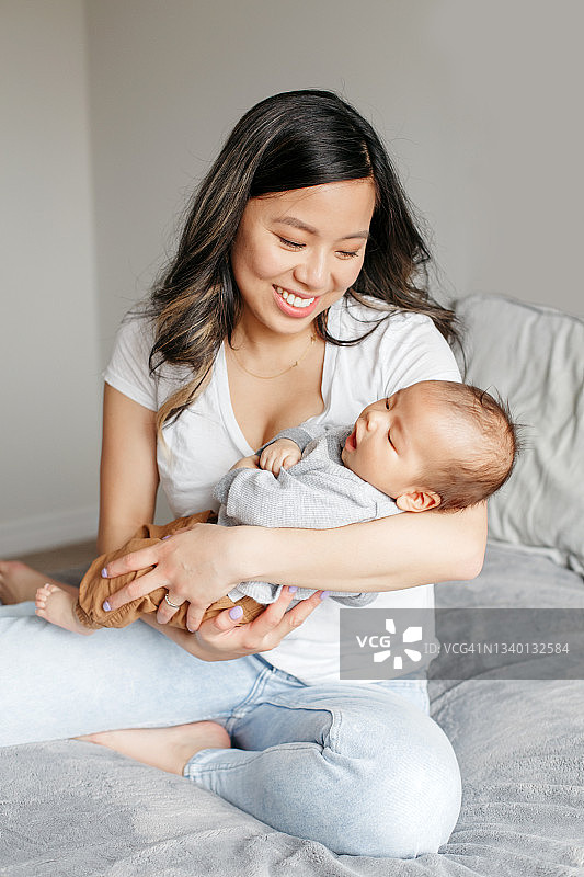 自豪微笑的中国亚洲母亲抱着新生男婴图片素材
