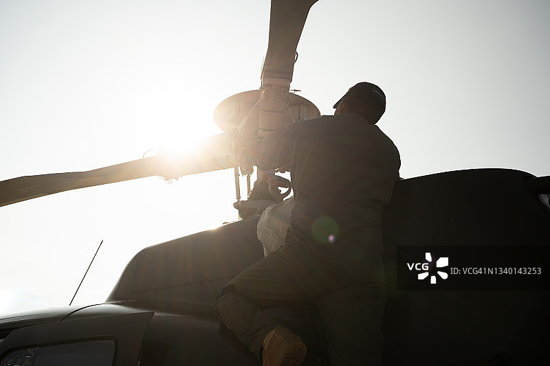 阳光下清洁直升机的军人图片素材