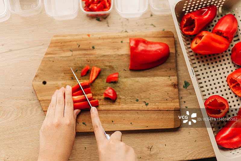 冬季食物储备：厨师将甜椒放入塑料容器冷冻图片素材