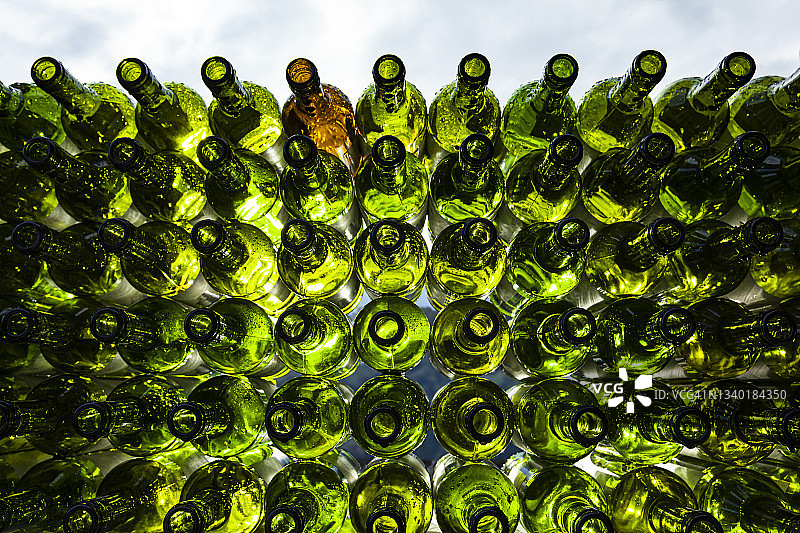 大量绿色玻璃罐和棕色罐子整齐地排列着，等待回收图片素材