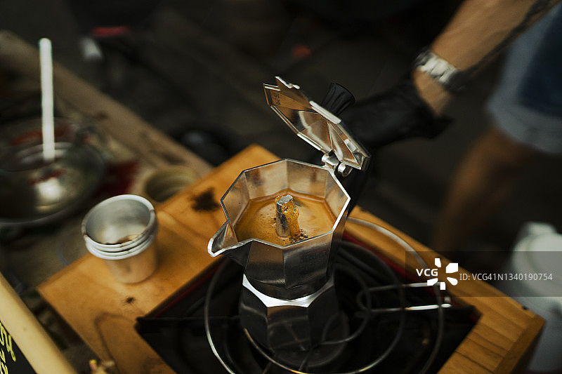 咖啡师用摩卡壶在炉子上制作浓缩咖啡图片素材