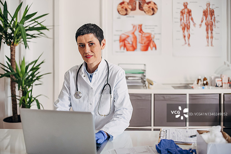 女医生坐在桌前用电脑工作的画像图片素材