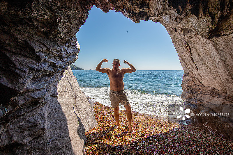 年长的男人在海滩上展示肌肉图片素材