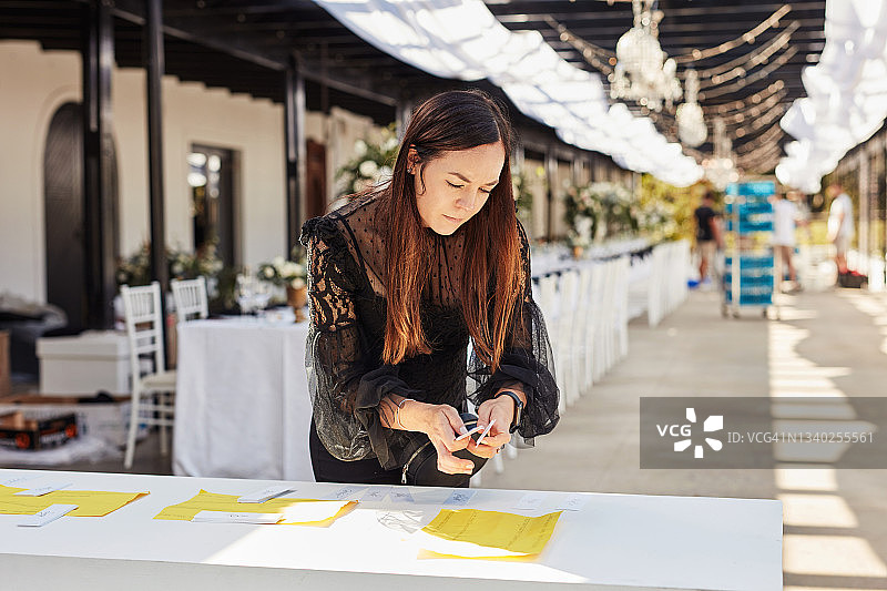 年轻女人装饰餐桌，准备婚礼招待会图片素材