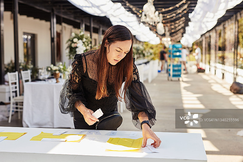 年轻女人装饰餐桌，准备婚礼招待会图片素材