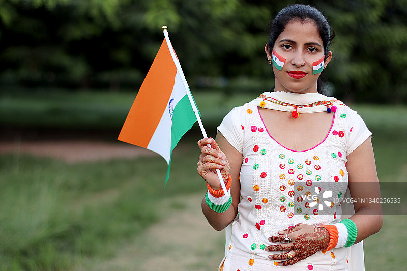 手持印度国旗的年轻印度女人图片素材