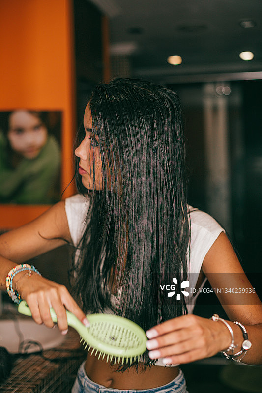 在浴室梳头的漂亮女人图片素材