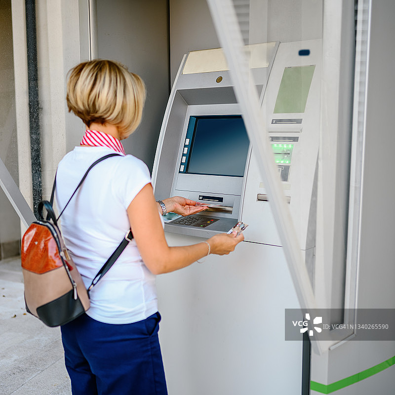 女人在自动取款机上取款图片素材