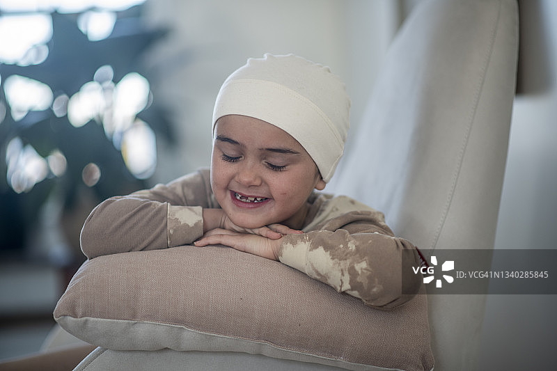 患癌症的年轻女孩靠在椅子扶手上图片素材