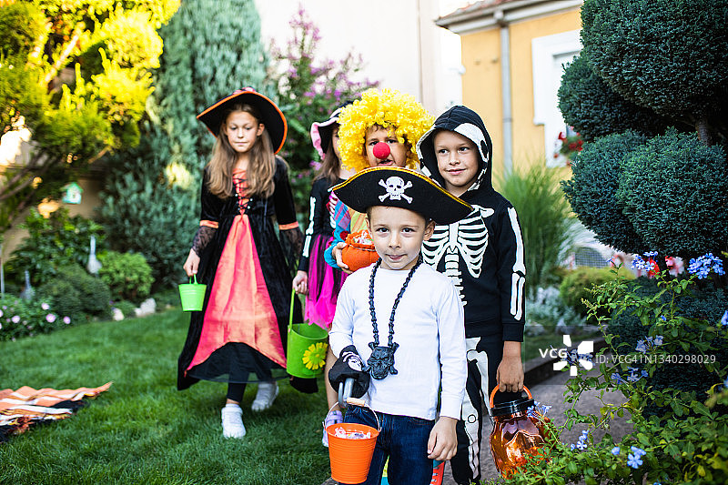 穿着万圣节服装要糖果的可爱孩子们图片素材