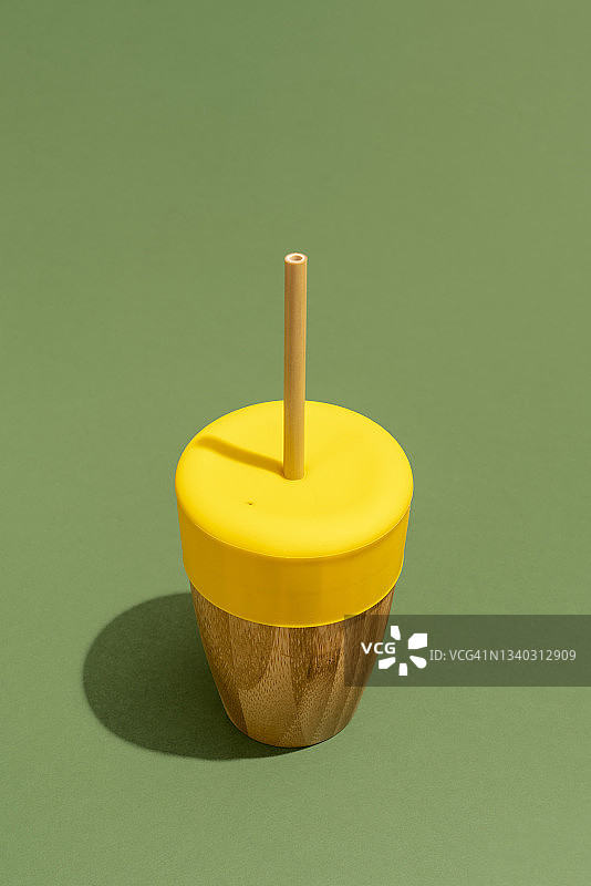 绿色背景上的环保可重复使用竹杯图片素材