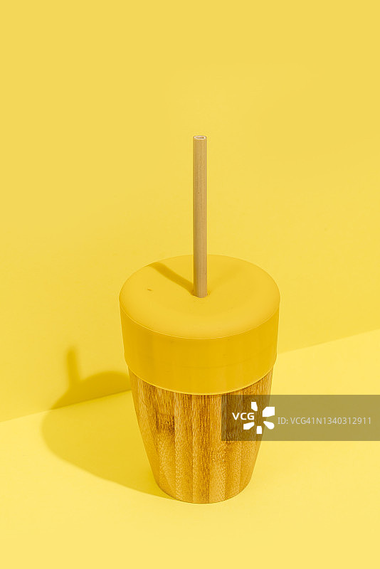 黄色背景上的生态可重复使用竹杯图片素材