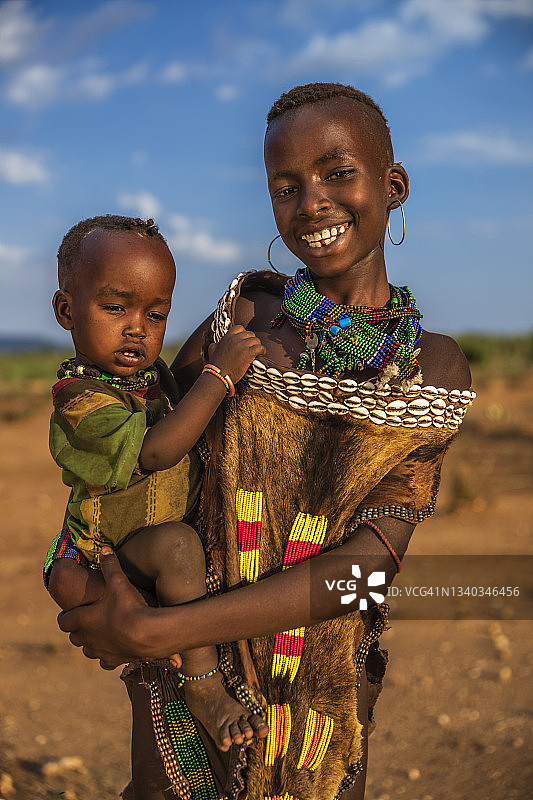 来自哈默部落的年轻女孩抱着她的妹妹，非洲埃塞俄比亚图片素材