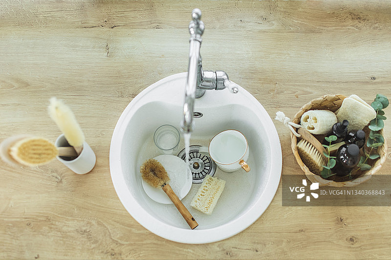 装有天然环保清洁产品和刷子的稻草篮，放置在厨房的台面上图片素材