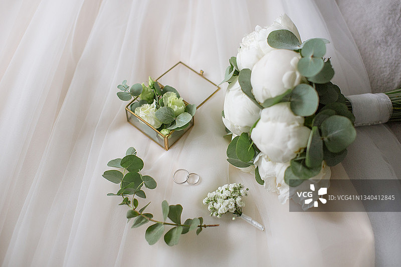 珠宝盒、婚礼花束和用绿色植物装饰的胸花图片素材
