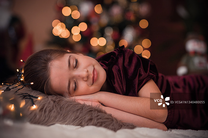 在圣诞节前夕睡觉的可爱年轻女孩图片素材