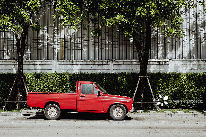树木背景下的经典红色皮卡车图片素材