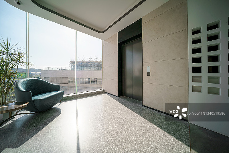 明亮电梯入口，窗边配有沙发图片素材