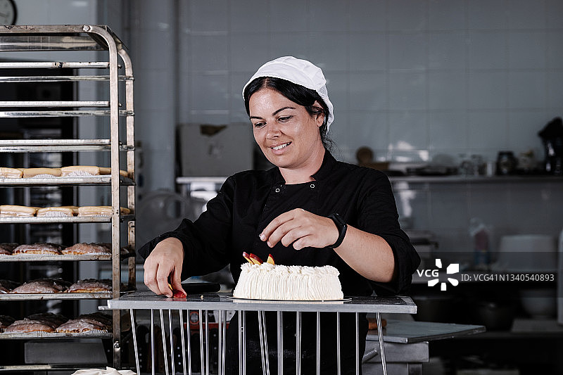 女糕点师用水果装饰蛋白酥皮馅饼图片素材