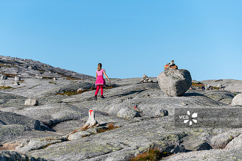 女孩在挪威徒步前往奇迹石图片素材