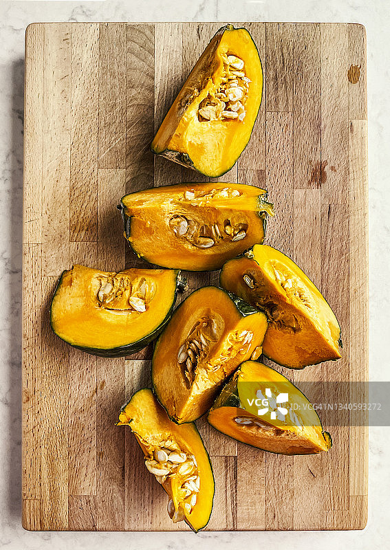 木制砧板上的日本南瓜切片图片素材
