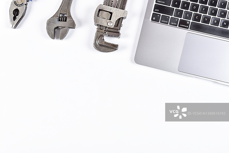 白色背景下的水管工具和设备及笔记本电脑图片素材