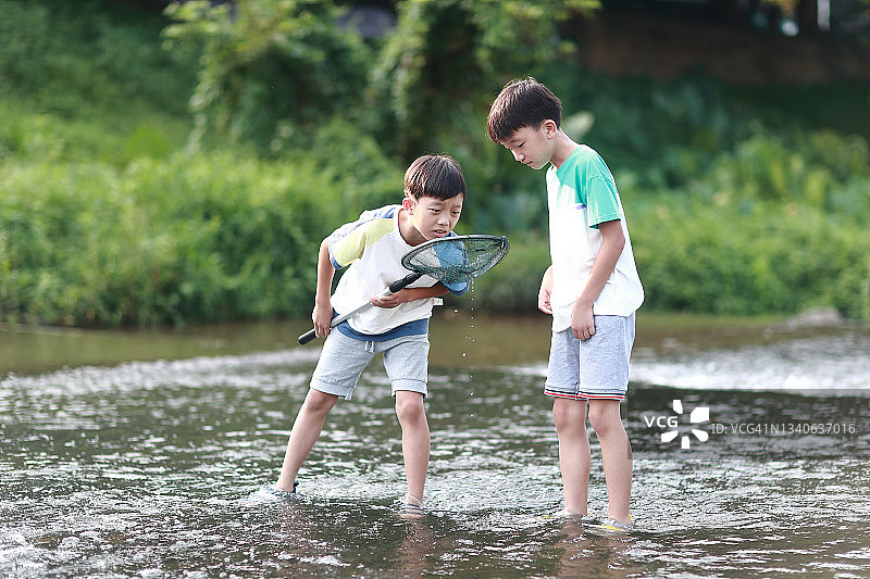 在小溪里钓鱼的男孩们图片素材