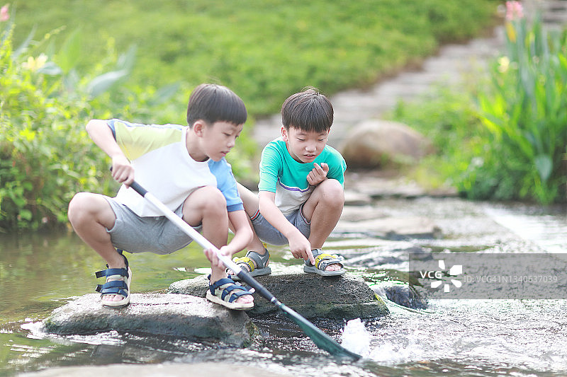 在小溪里钓鱼的男孩们图片素材