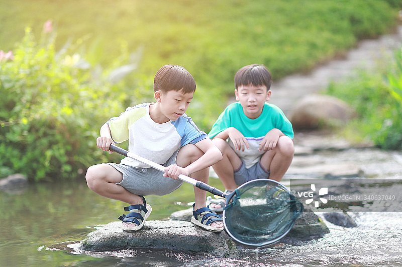 在小溪里钓鱼的男孩们图片素材
