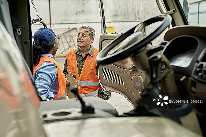 卡车司机在装货码头与工人交流图片素材