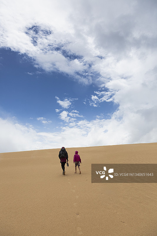母亲和儿子在澳大利亚维多利亚州威尔逊斯岬的沙丘上行走图片素材