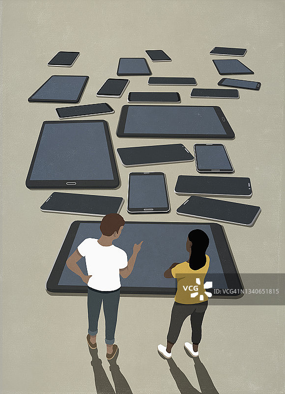 情侣看各种智能手机和平板电脑图片素材