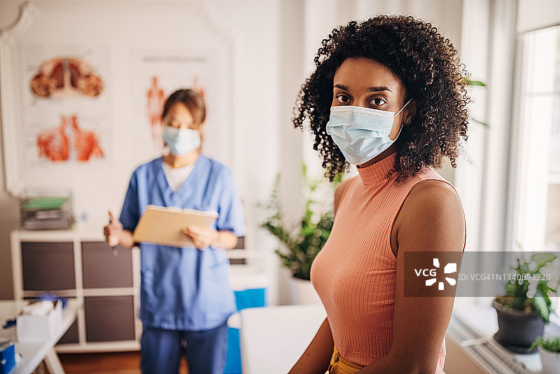 新冠诊所的病人，护士正在记录医疗图表图片素材