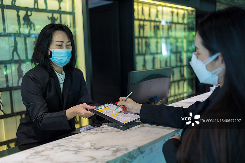 女顾客使用信用卡向酒店付款图片素材