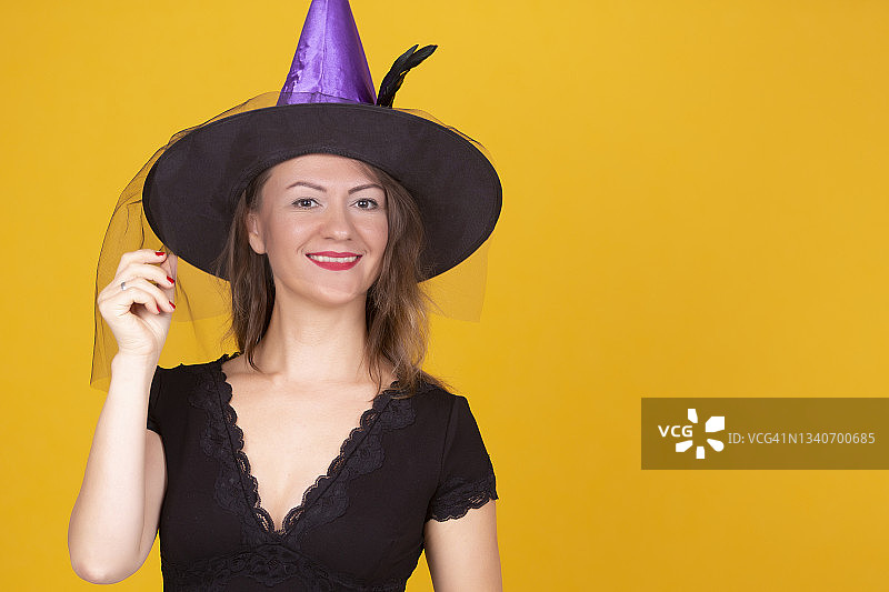 穿着万圣节服装站在橙色背景前的女人肖像图片素材