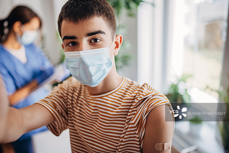 青少年在诊所接种新冠疫苗自拍图片素材