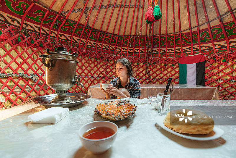女子在蒙古包里用茶炊喝茶图片素材