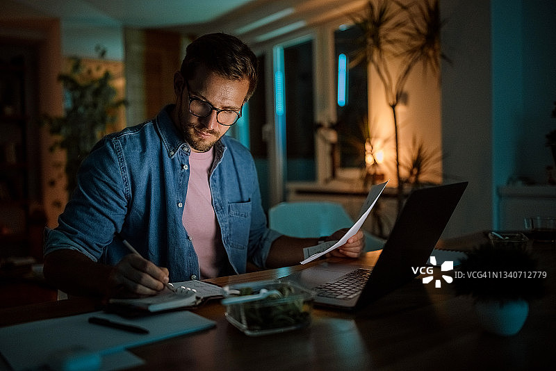 认真的帅气男人在家熬夜工作图片素材